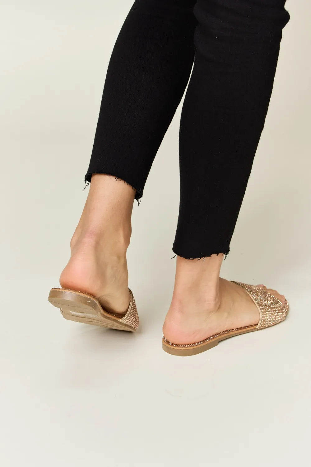 Rhinestone Open Toe Flat Sandals in rose gold with black pants