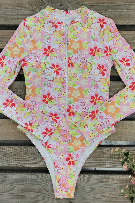Floral Print One Piece Long Sleeve UPF50 Swimsuit with a white zipper on a wooden surface