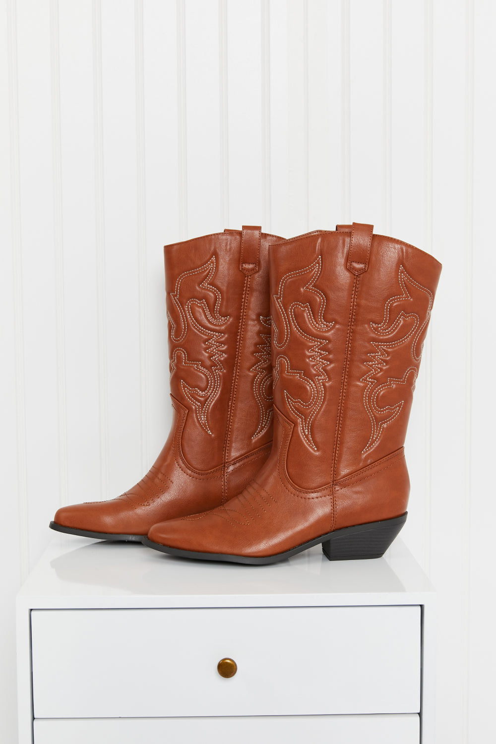 Embroidered Mid-Calf Cowboy Boots in brown with white stitching on a white surface