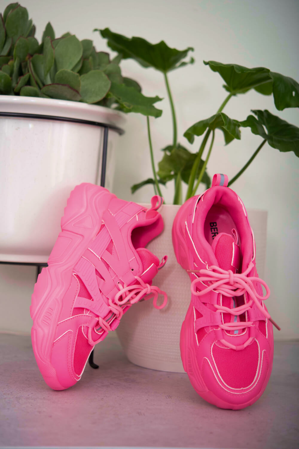 Running Late Chunky Sole Sneakers in Hot Pink, with plants in the background