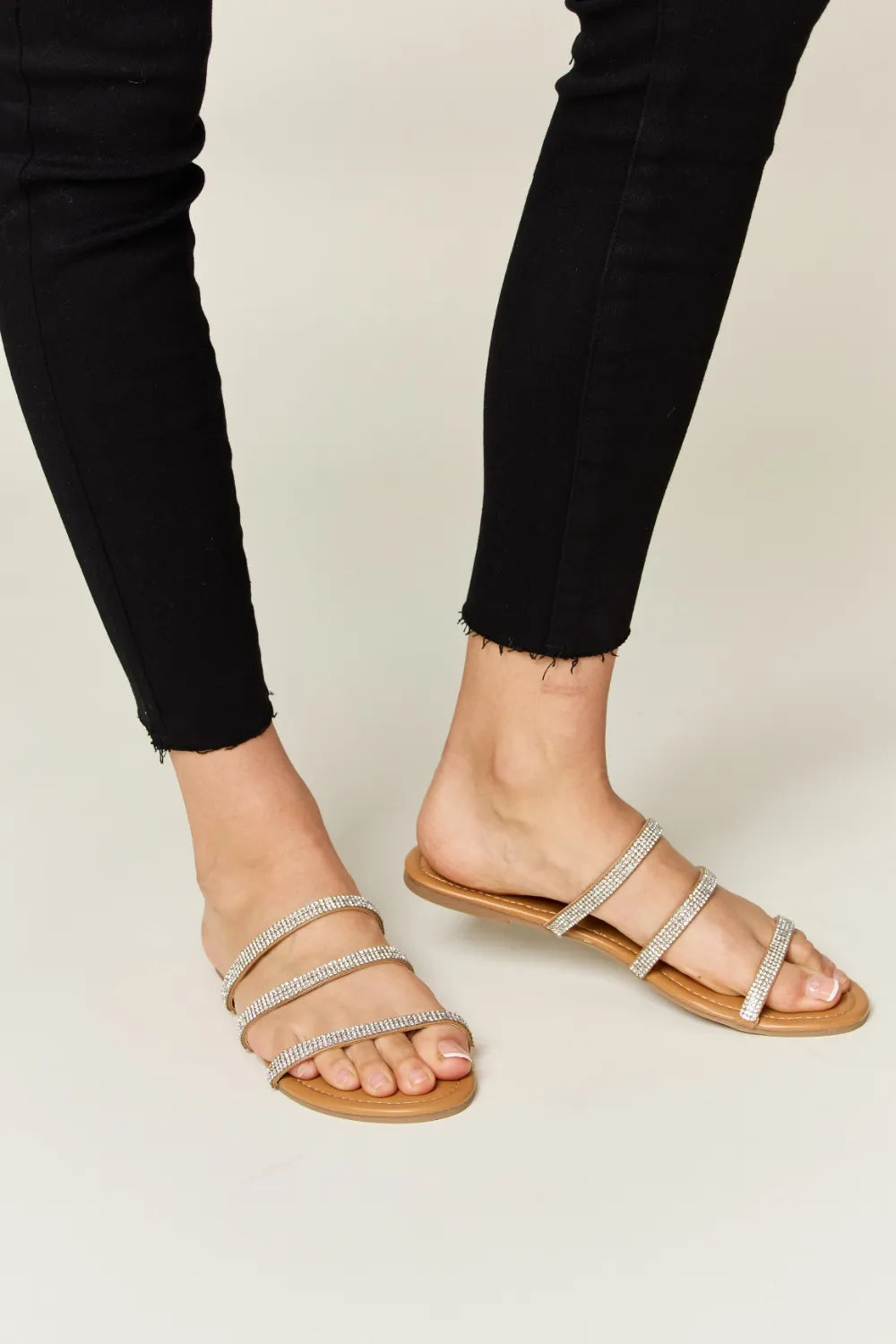 Rhinestone Three-Strap Flat Sandals on feet with black pants