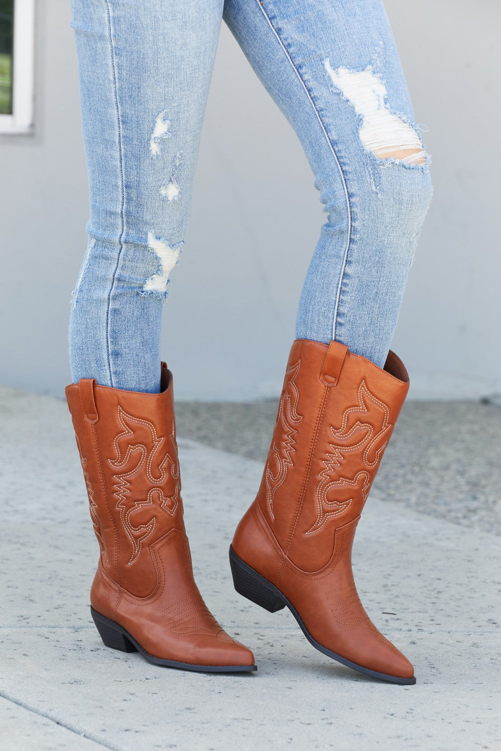 Embroidered Mid-Calf Cowboy Boots in brown with white stitching, worn with distressed light wash jeans
