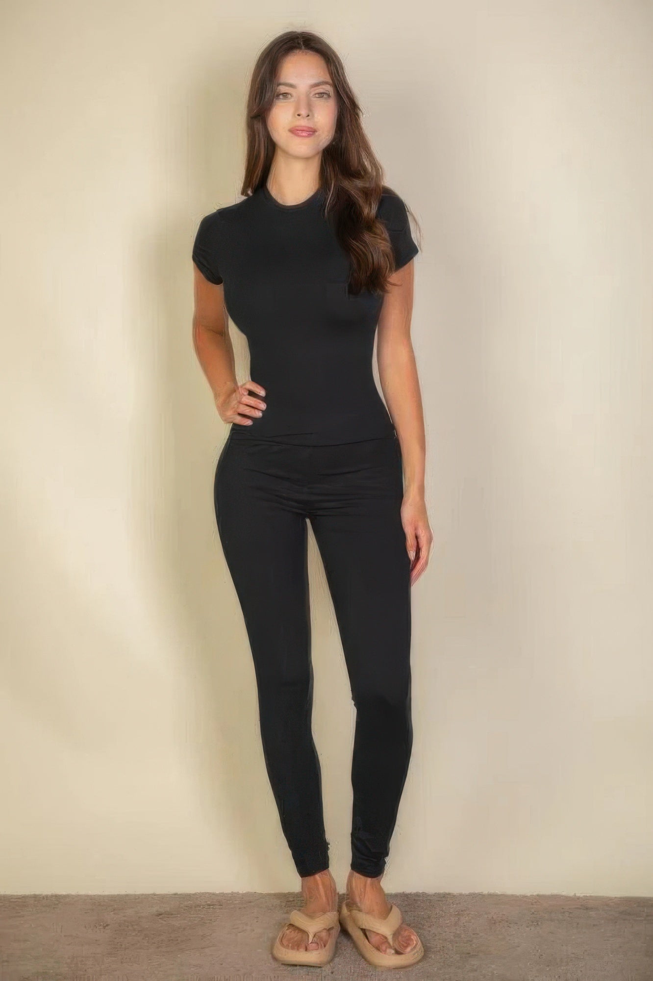 Woman wearing black basic solid leggings and a black short-sleeved top
