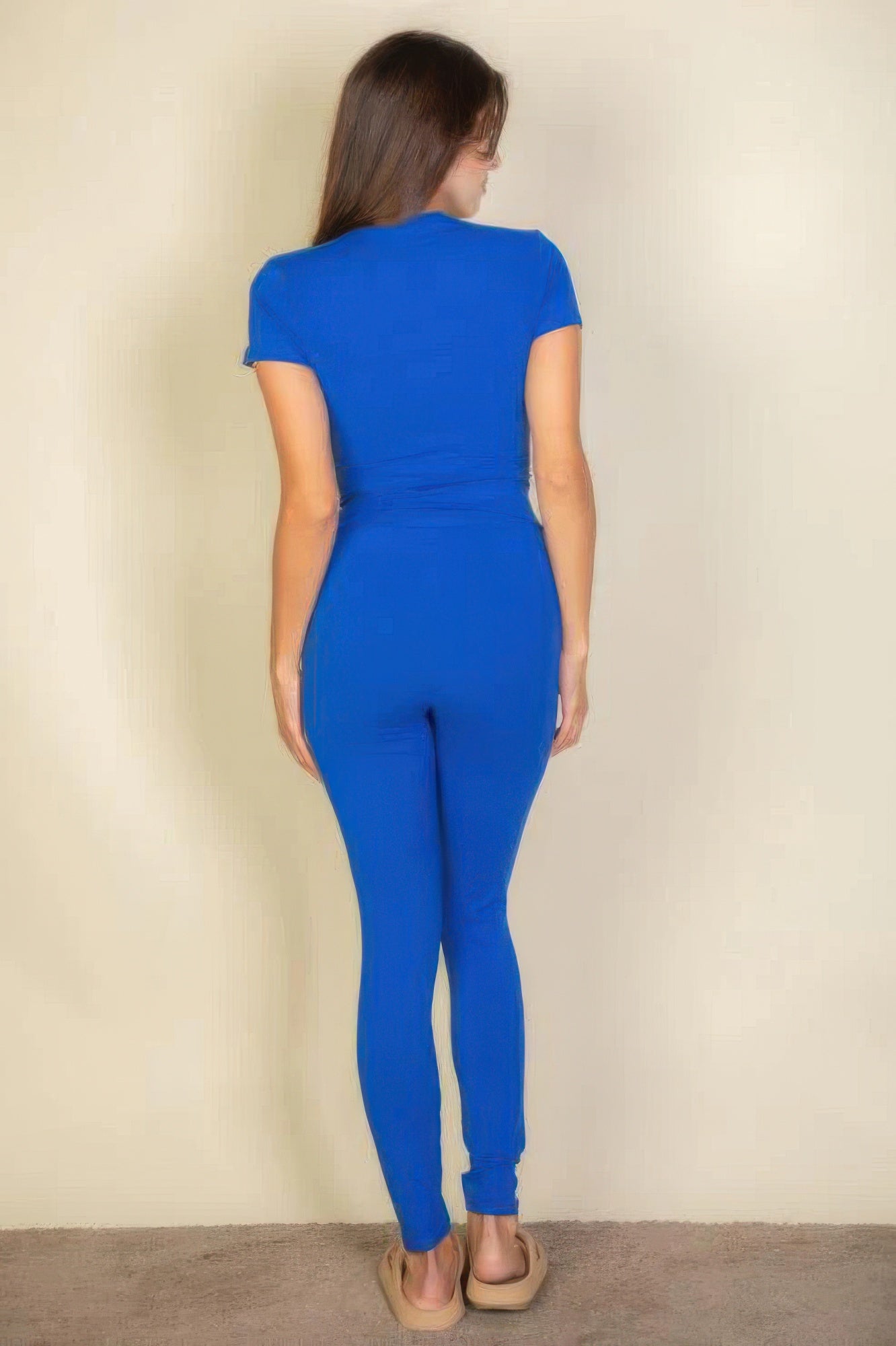 Woman from behind wearing blue basic solid leggings and a matching top