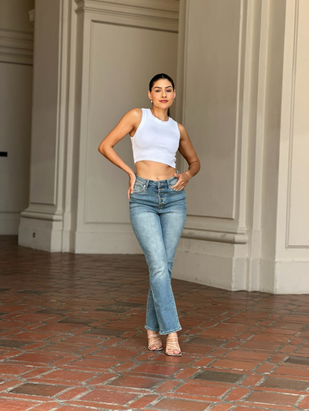 Woman wearing High Rise Cigarette Button Fly Straight Jeans and a white crop top