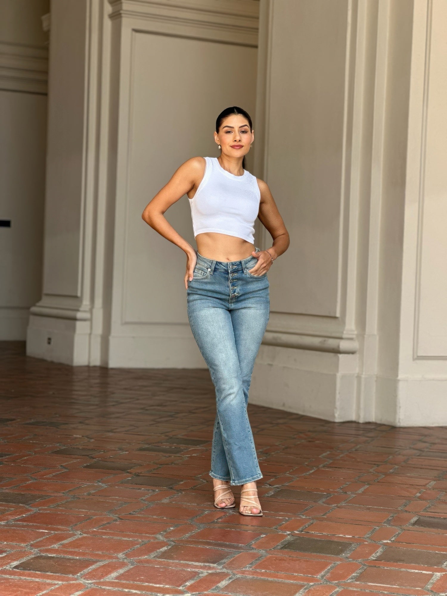Woman wearing High Rise Cigarette Button Fly Straight Jeans and a white crop top