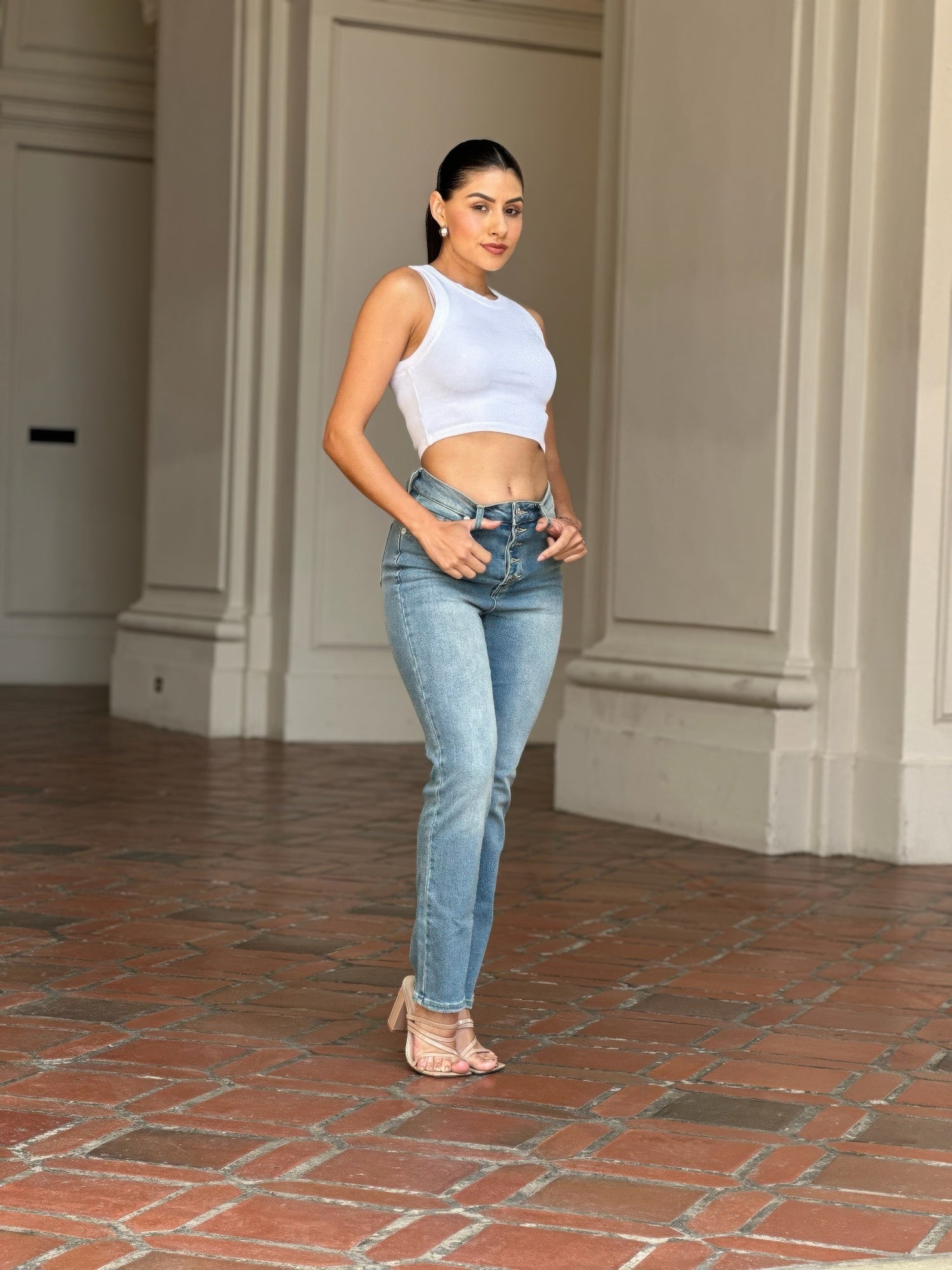 Woman wearing High Rise Cigarette Button Fly Straight Jeans and a white crop top