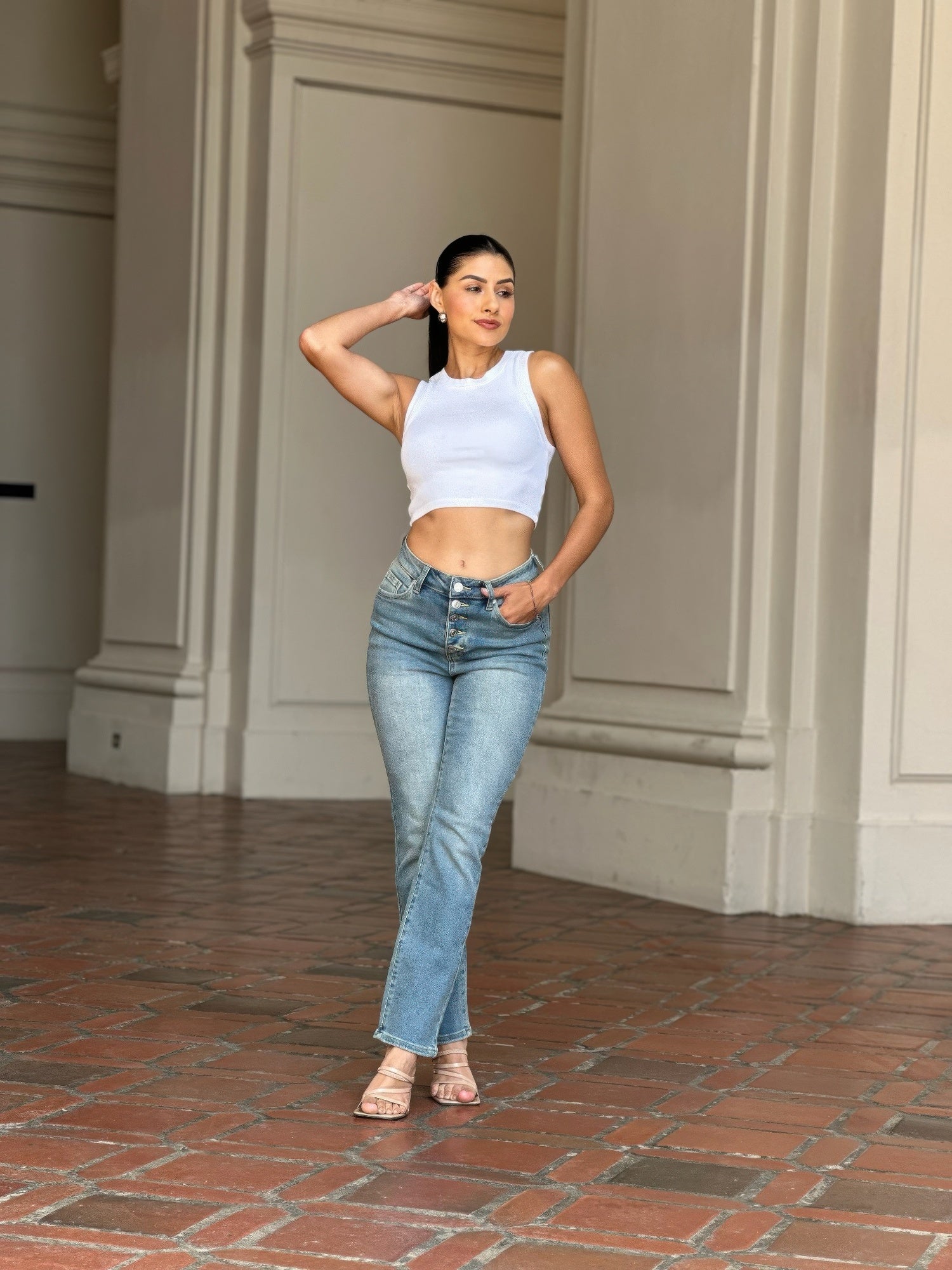 Woman wearing High Rise Cigarette Button Fly Straight Jeans and a white crop top