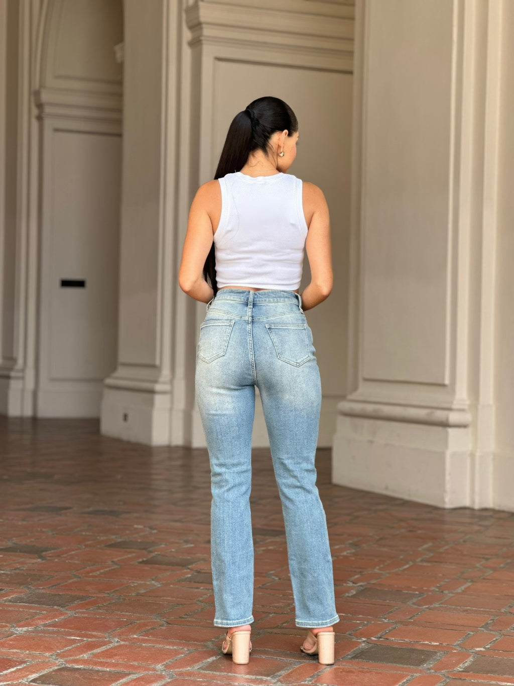 Woman from behind wearing High Rise Cigarette Button Fly Straight Jeans and a white top
