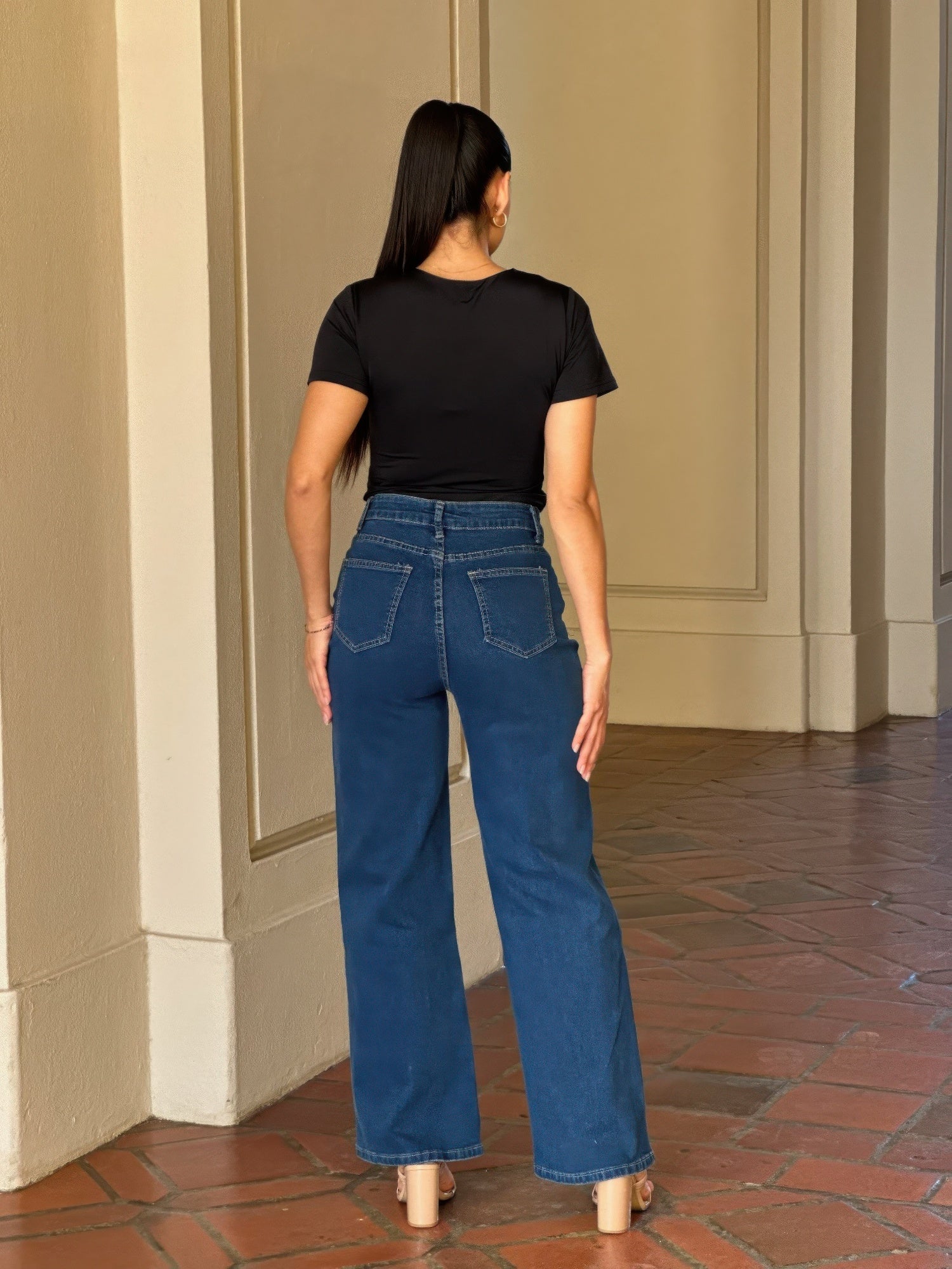Back view of a woman wearing Embroidered Wide Leg Jeans and a black top