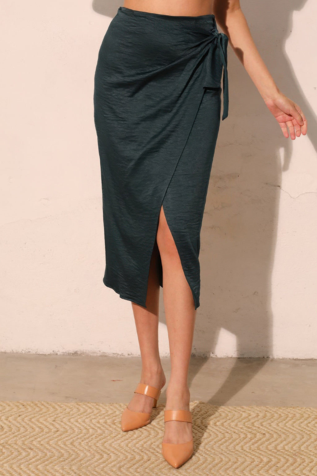 Midnight Teal Wrap-Front Midi Skirt with a side tie detail and a front slit, paired with nude heels