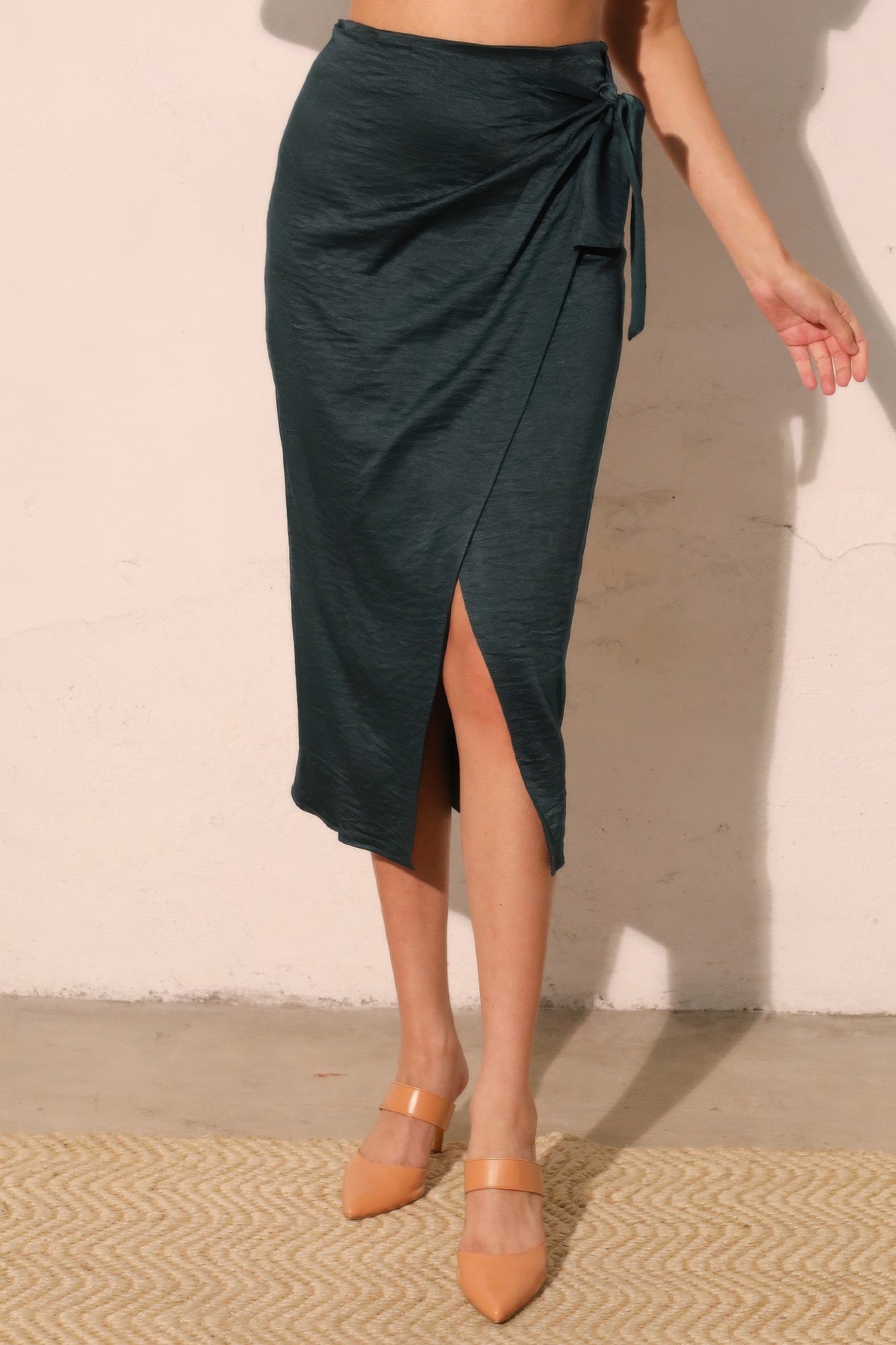 Midnight Teal Wrap-Front Midi Skirt with a side tie detail and a front slit, paired with nude heels