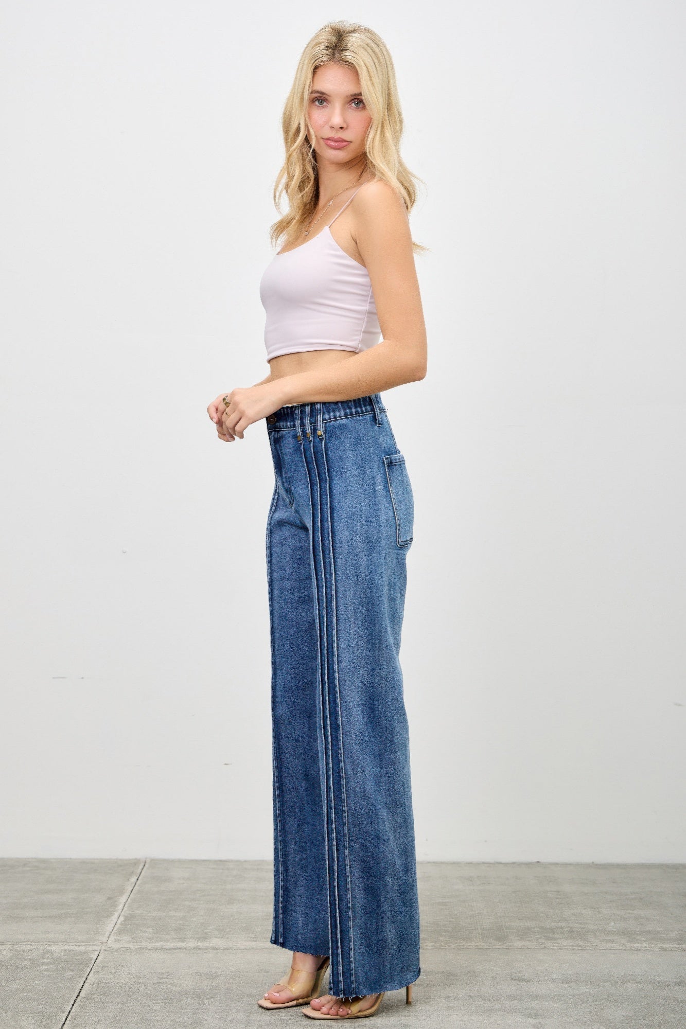 Blonde woman wearing High Rise Straight Jeans with Front Line Detail and a light pink crop top