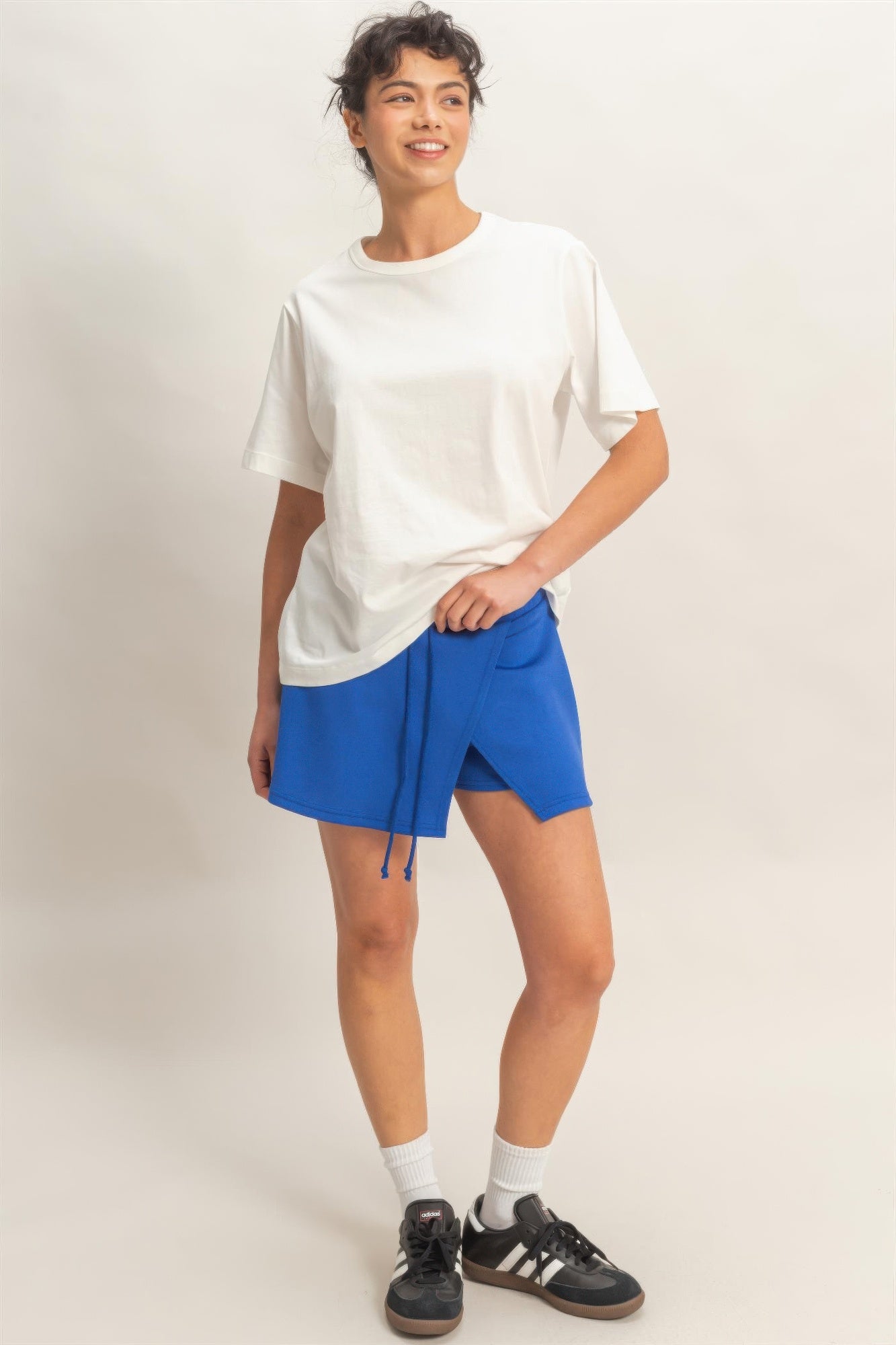 Woman wearing a white t-shirt and Cobalt Azure Wrap Skort