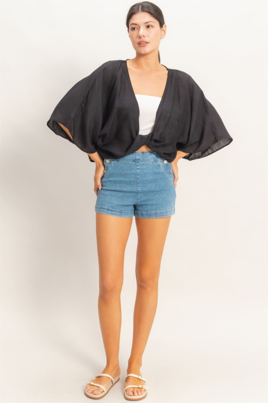 Ink Black Twist-Front Draped Shrug Top worn over a white bandeau and denim shorts