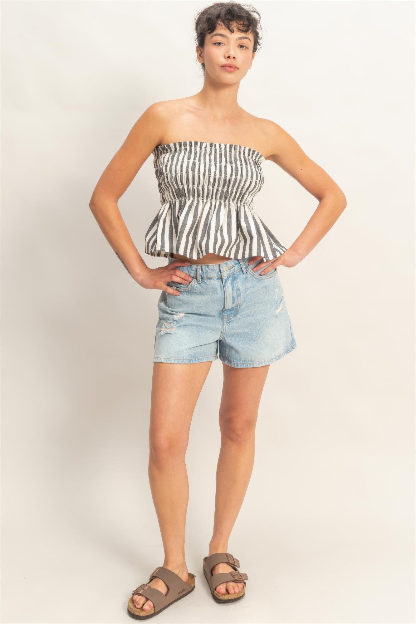 Ivory Ink Stripe Smocked Peplum Strapless Top with light wash denim shorts and brown sandals