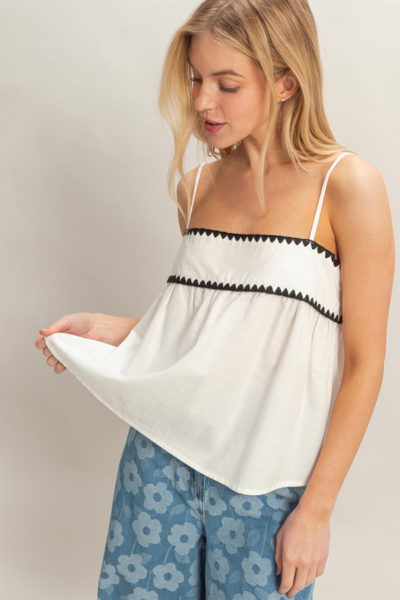 Porcelain White Contrast-Trim Babydoll Tank Top with black trim, worn by a model with blonde hair