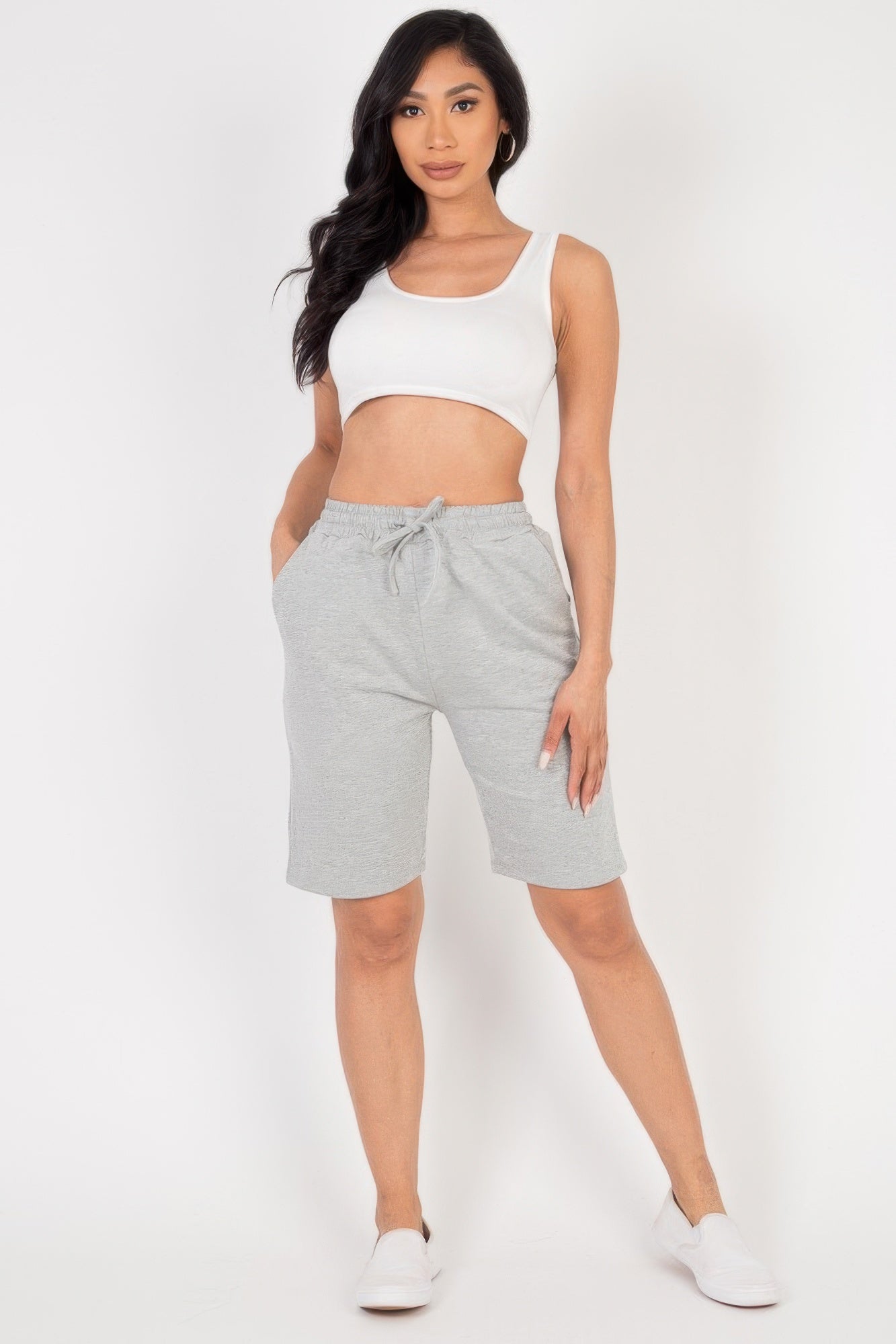 Woman wearing Smocked-Waist Bermuda Shorts and a white crop top