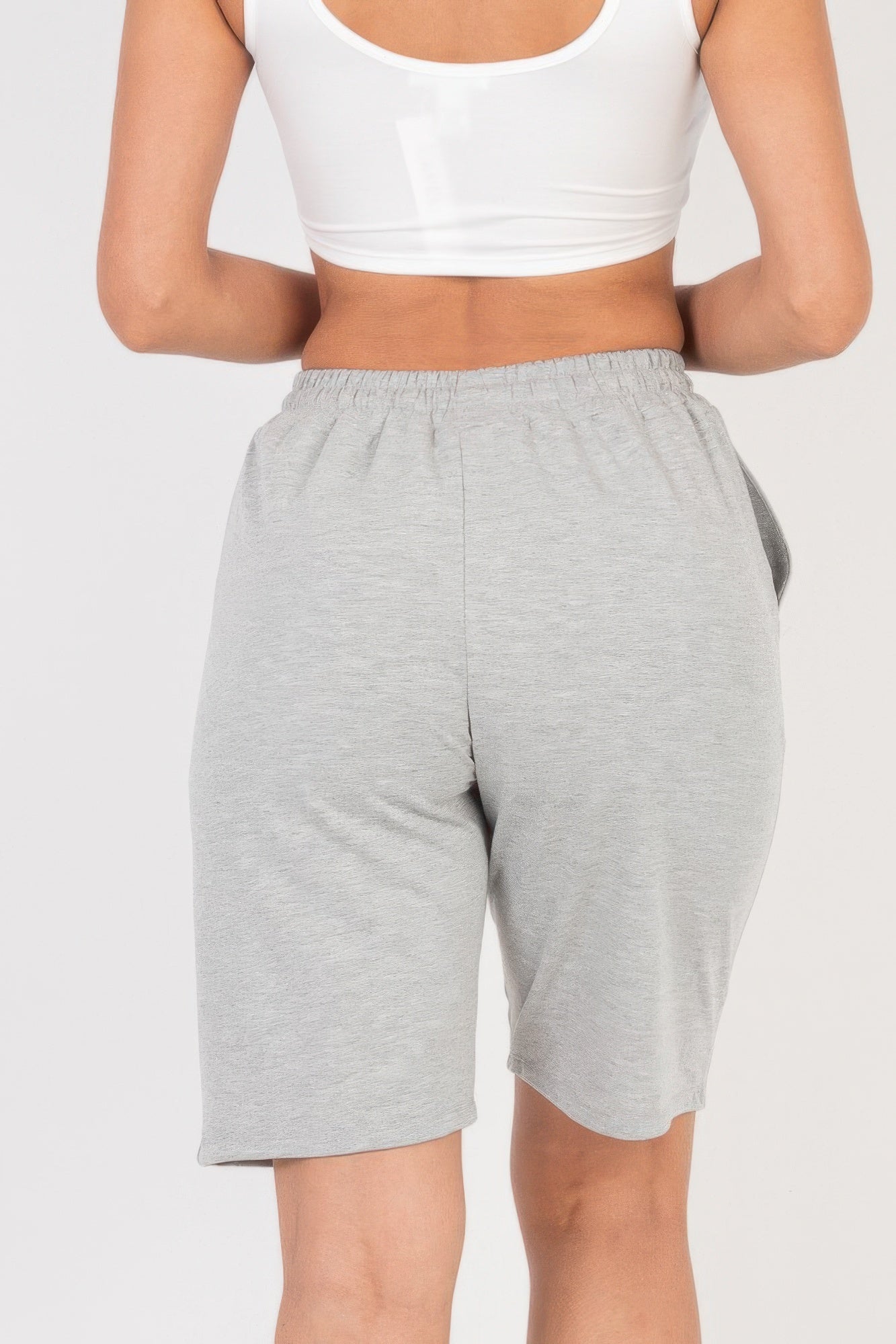 Back view of Smocked-Waist Bermuda Shorts in light grey with a white crop top