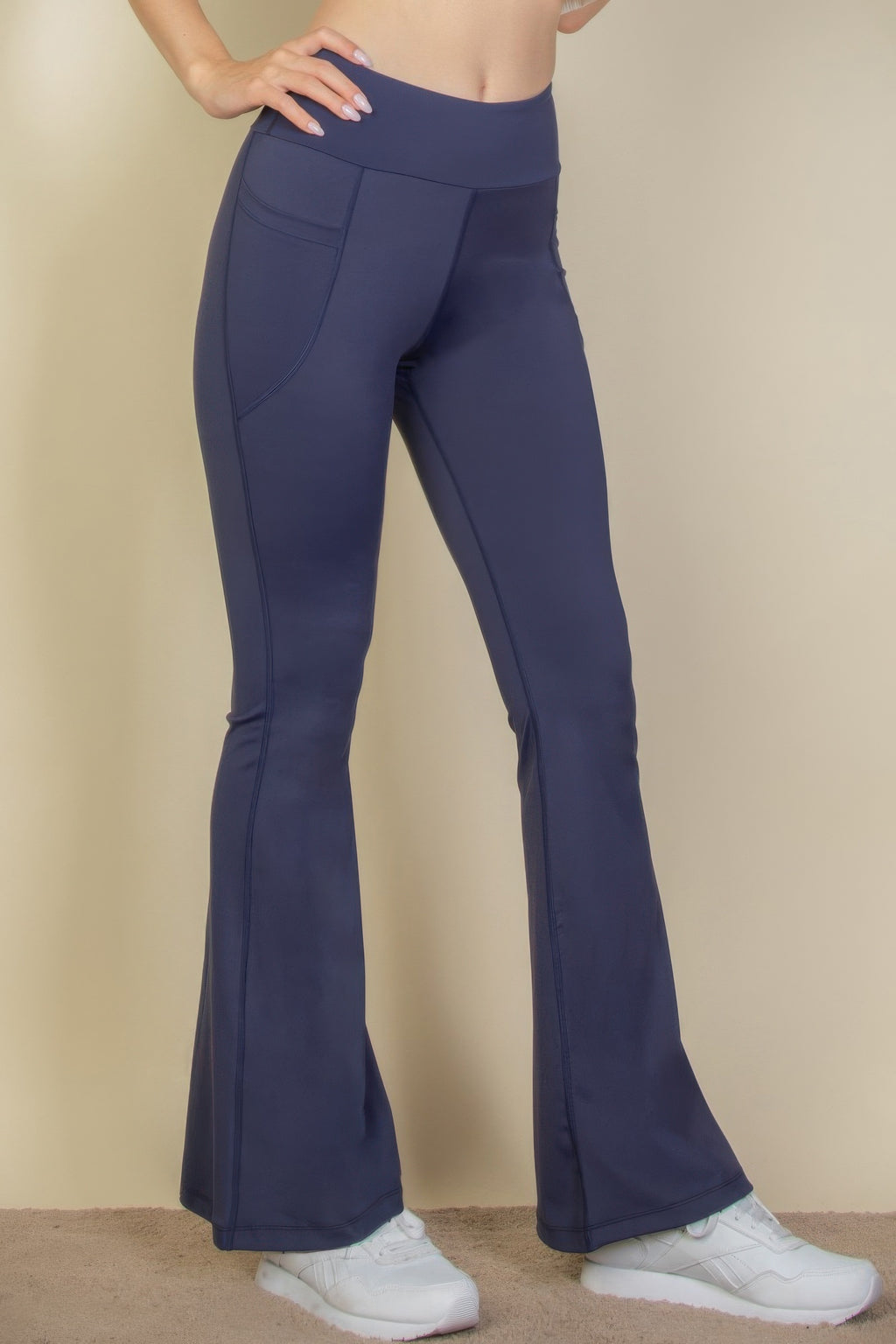 High-Waist Flare Leggings with Side Pockets in navy blue, worn by a person with white sneakers