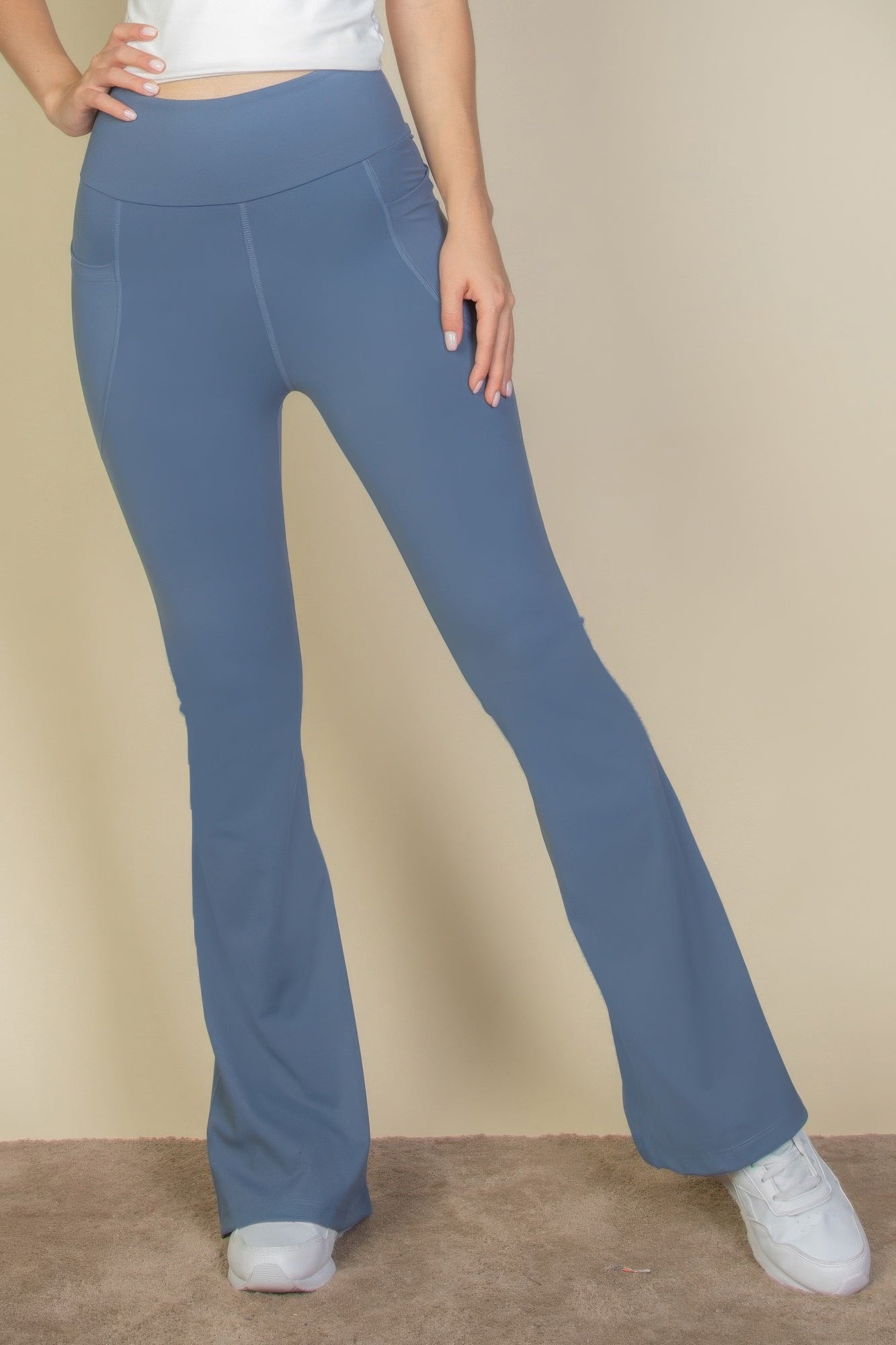 High-Waist Flare Leggings with Side Pockets in blue, worn by a person with white sneakers