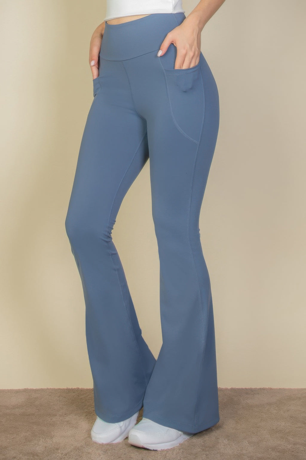 High-Waist Flare Leggings with Side Pockets in blue, worn by a person with hands in pockets