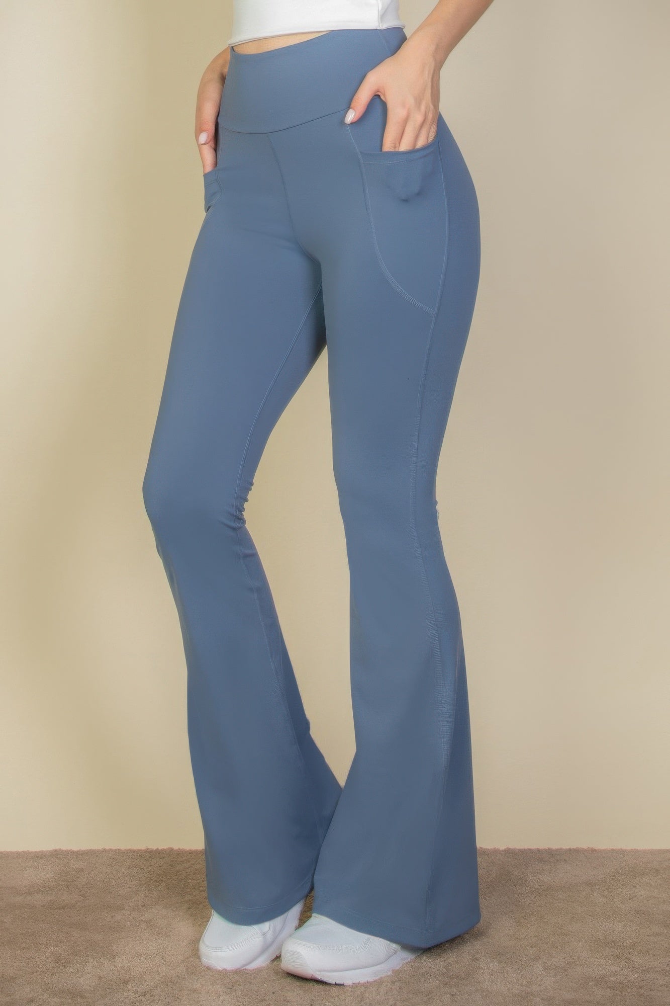 High-Waist Flare Leggings with Side Pockets in blue, worn by a person with hands in pockets