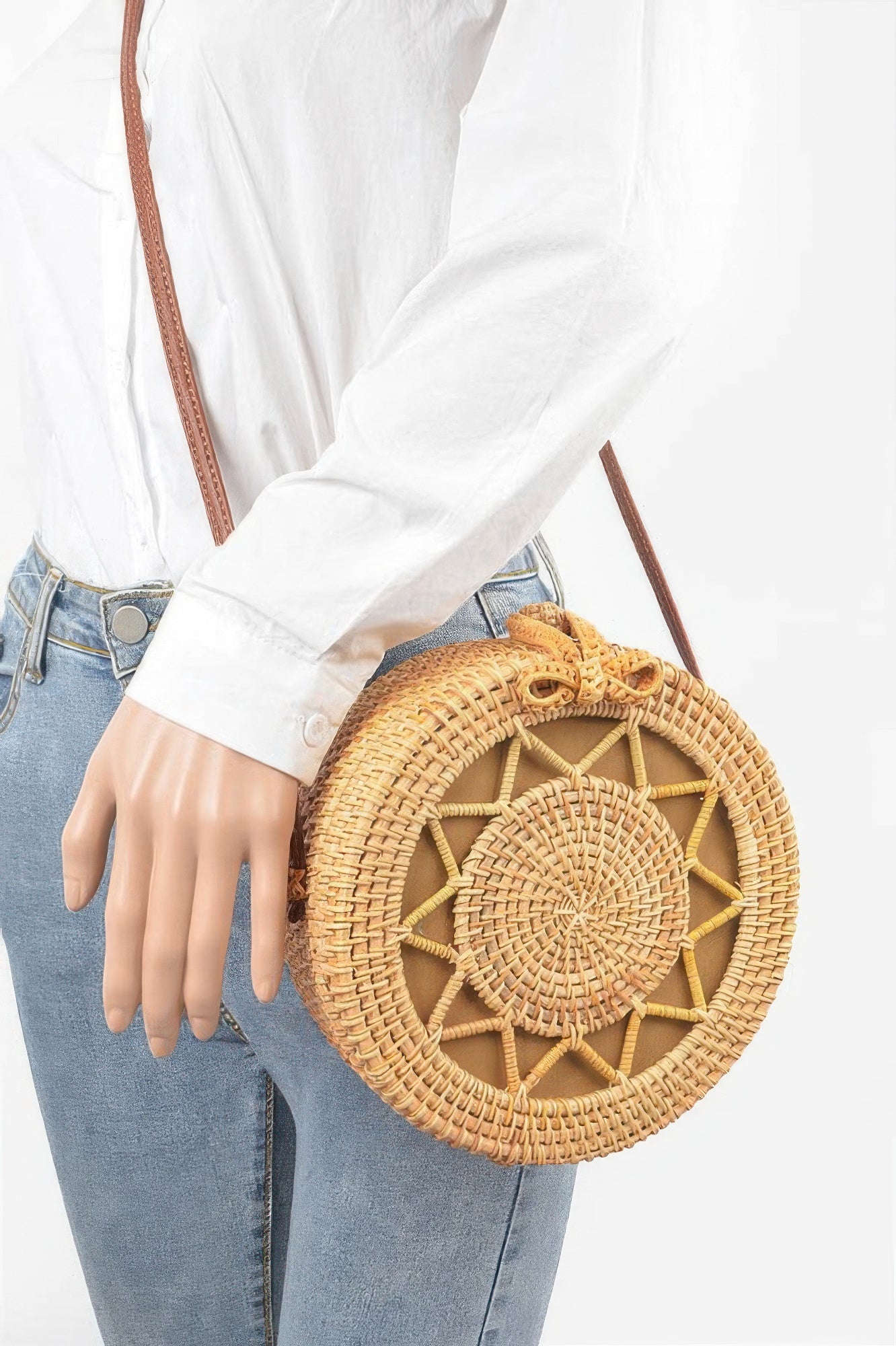 Bamboo Round Crossbody Bag with a brown leather strap, worn by a person in a white shirt and blue jeans