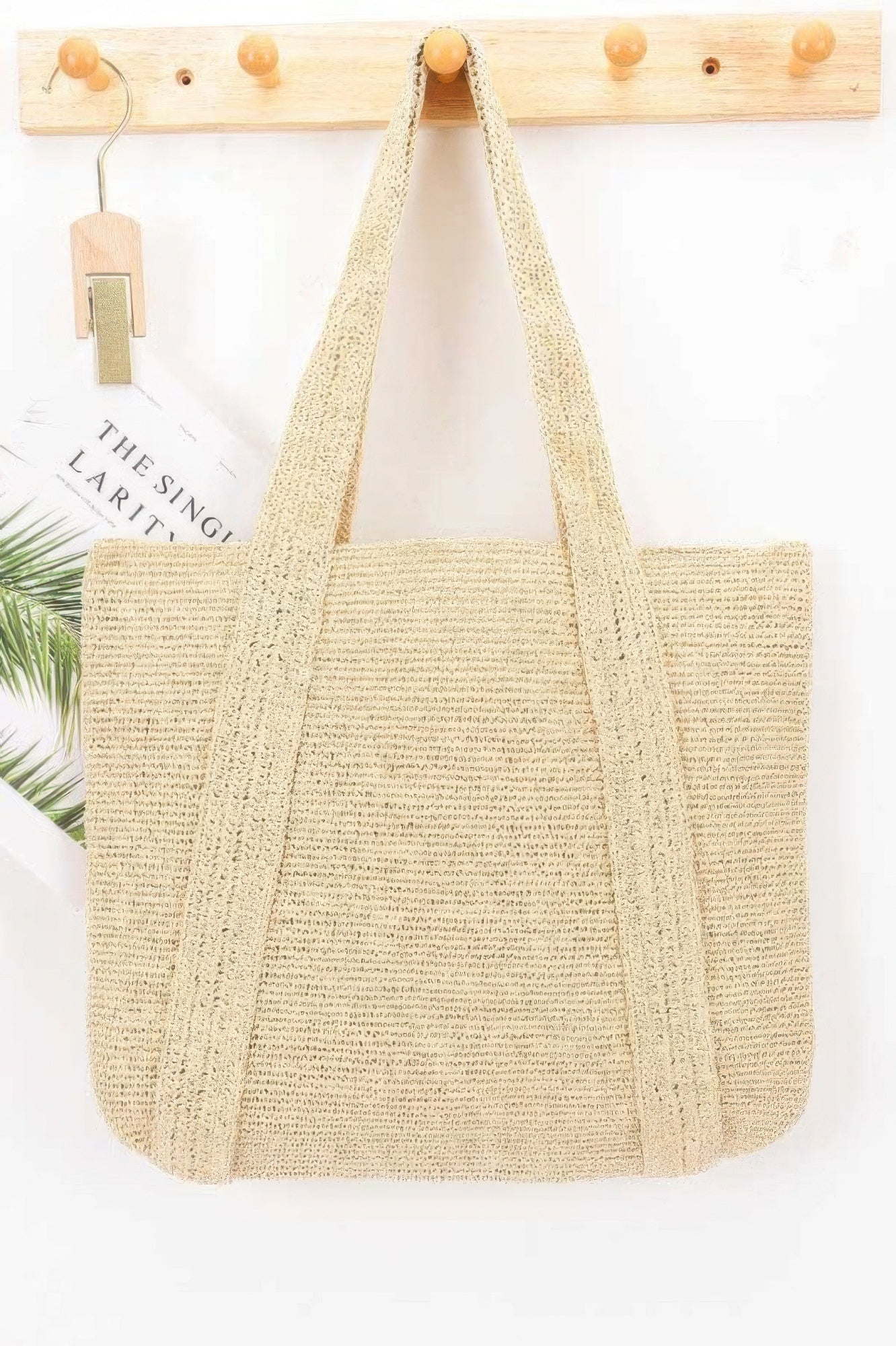 Woven Straw Tote Bag hanging on a wooden wall hook