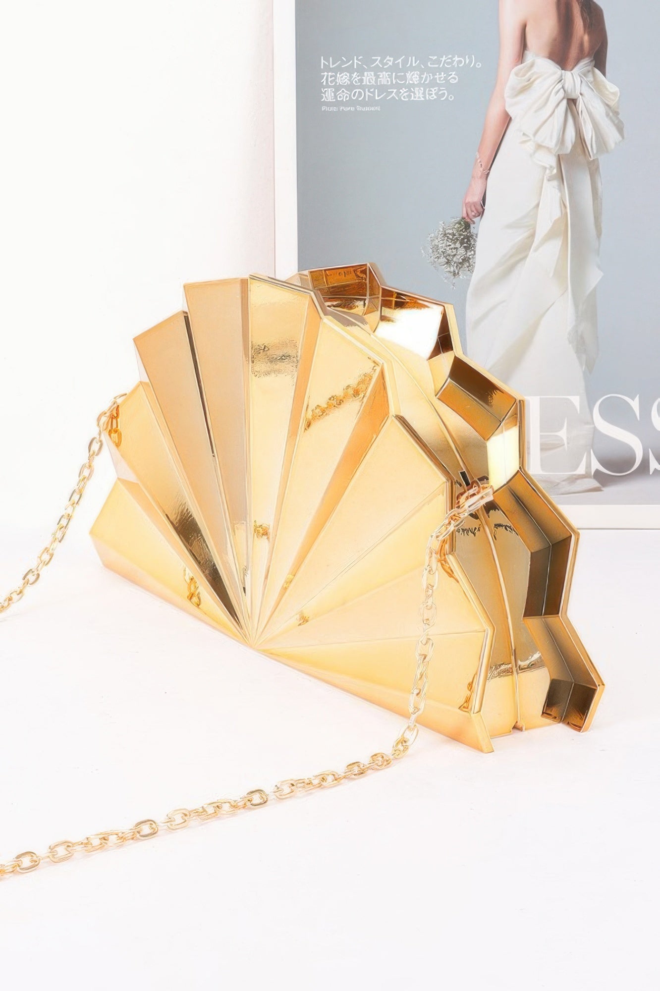 Metallic Acrylic Party Clutch in gold with a chain strap, fan-shaped design, and geometric facets