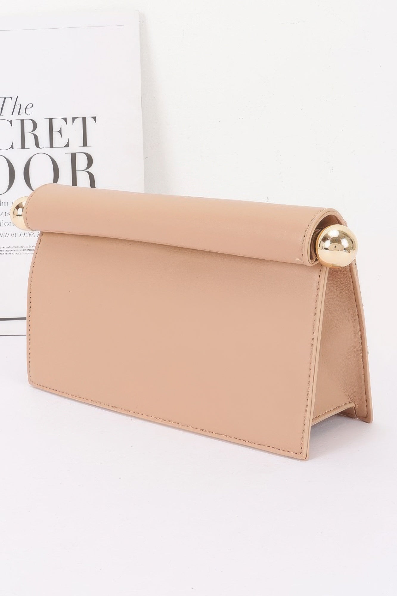 Roll-top Sphere Accent Chain Clutch in a light tan color with gold sphere accents