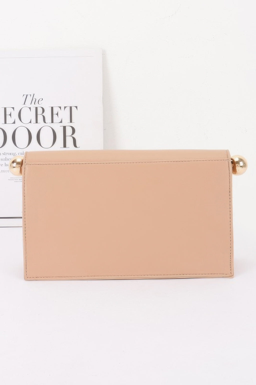 Roll-top Sphere Accent Chain Clutch in a light beige color with gold sphere accents
