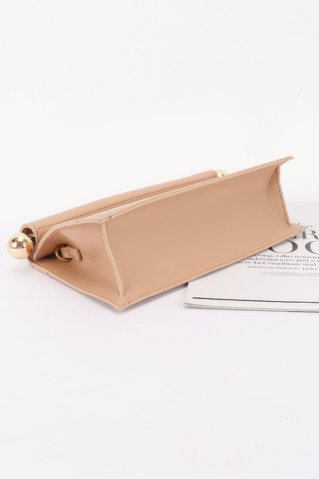 Roll-top Sphere Accent Chain Clutch in a light brown color, with a gold sphere accent on the side