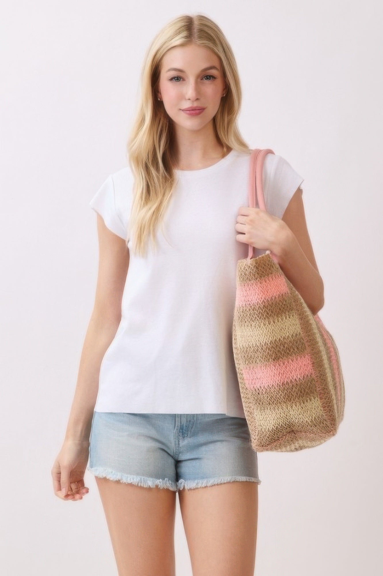Natural Brown Multi Color Stripe Straw Tote Bag carried by a woman in a white shirt and denim shorts