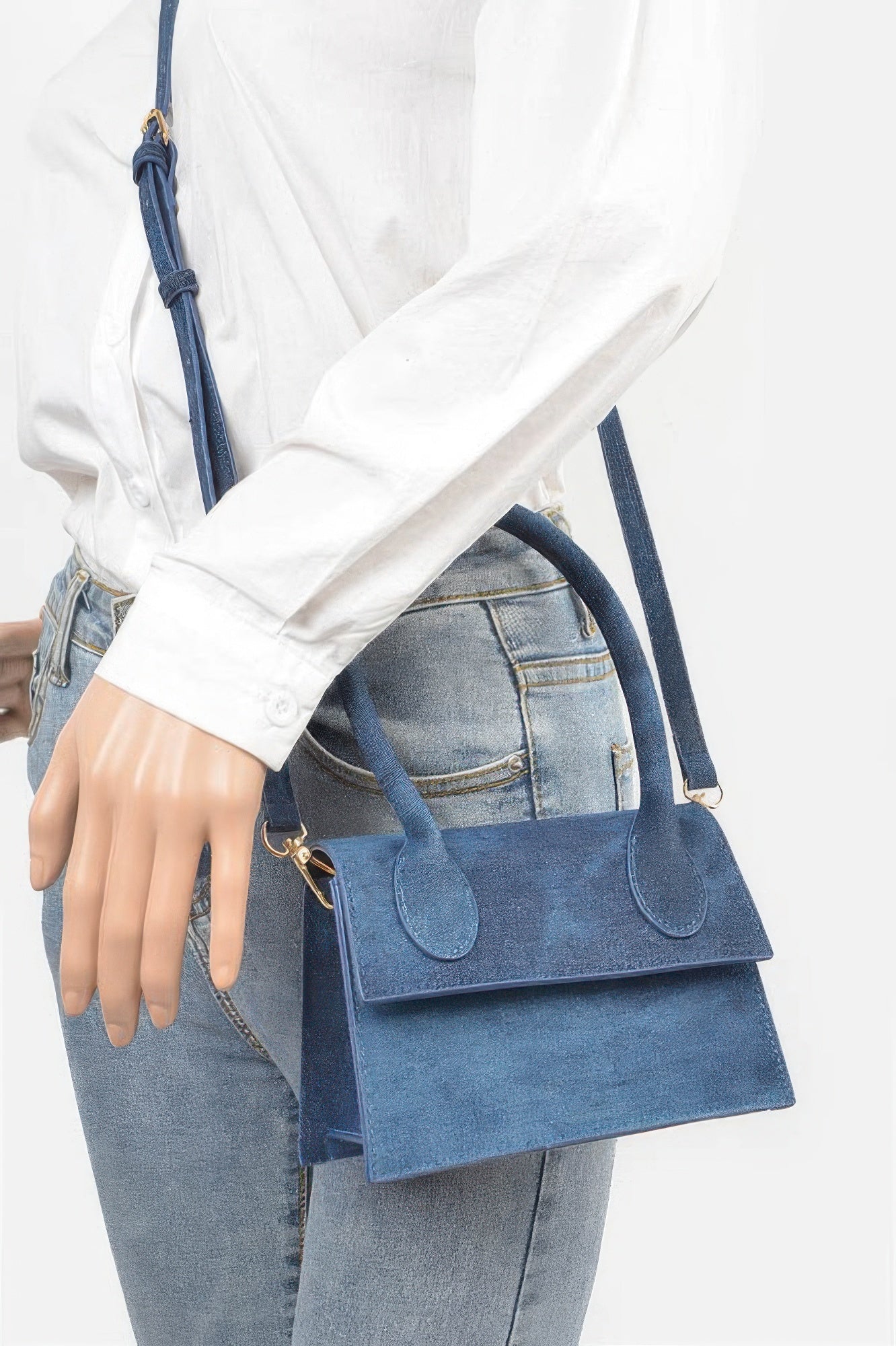 Denim Top Handle Crossbody Bag in blue denim with gold hardware, worn over the shoulder with a white shirt and jeans