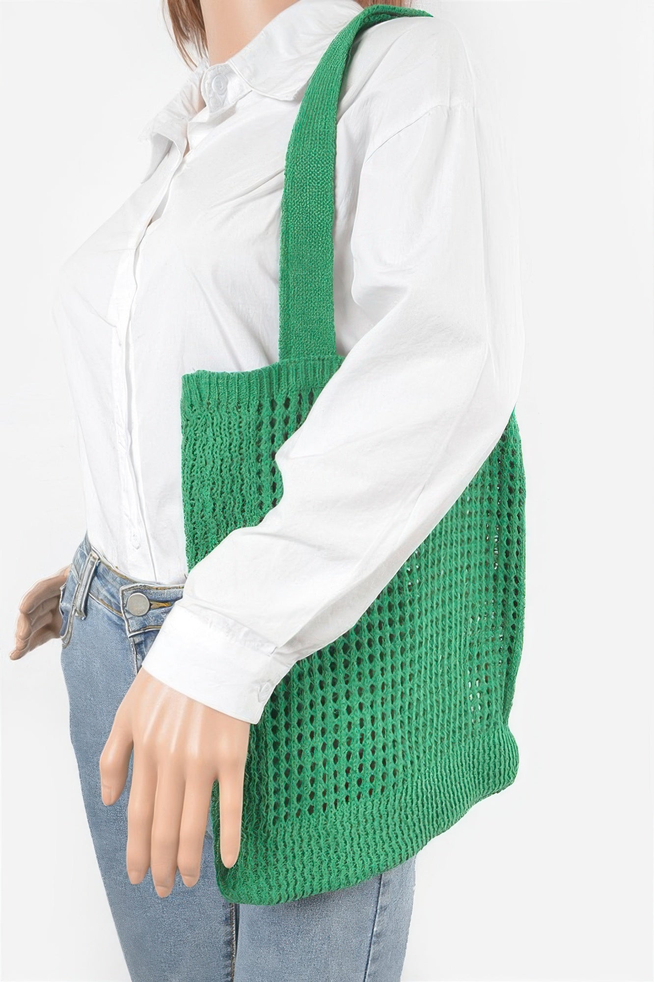 Knitted Tote Bag in green, worn over the shoulder by a mannequin in a white shirt and blue jeans