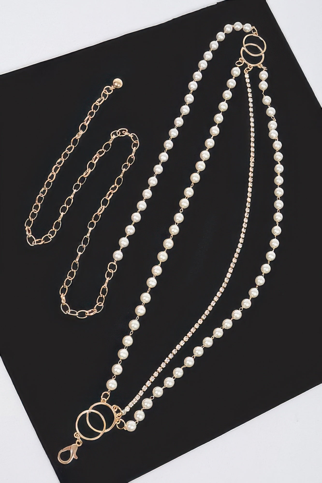 Pearl Layered Chain Belt with gold chains, pearls, and rhinestones on a black and white background