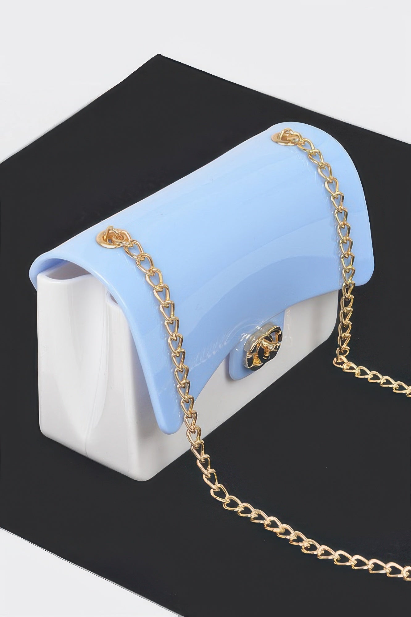 Two Toned Gold Metal Clutch with light blue flap and white body, gold chain strap, and gold clasp