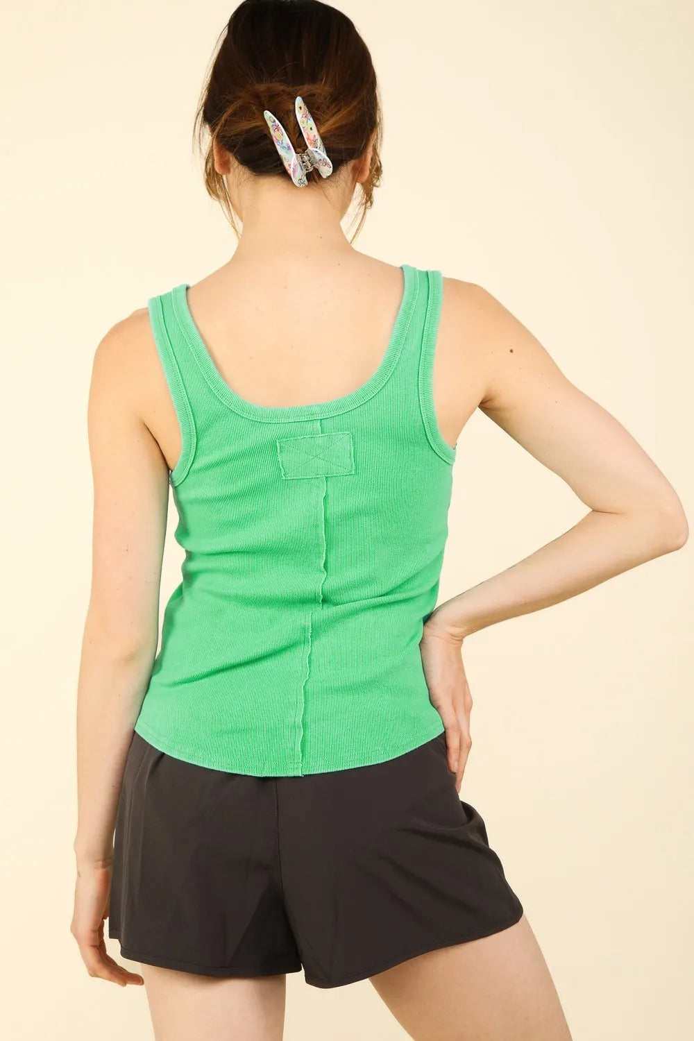 Back view of a woman wearing a Washed Ribbed Tank in green and dark shorts