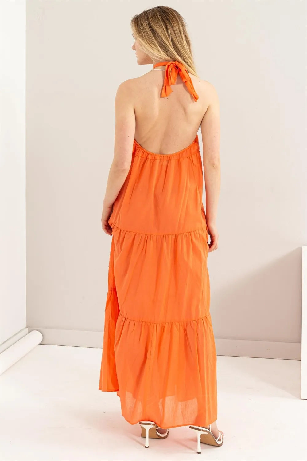 Back view of a woman wearing a HYFVE Halter Neck Cover Up Maxi Dress in orange