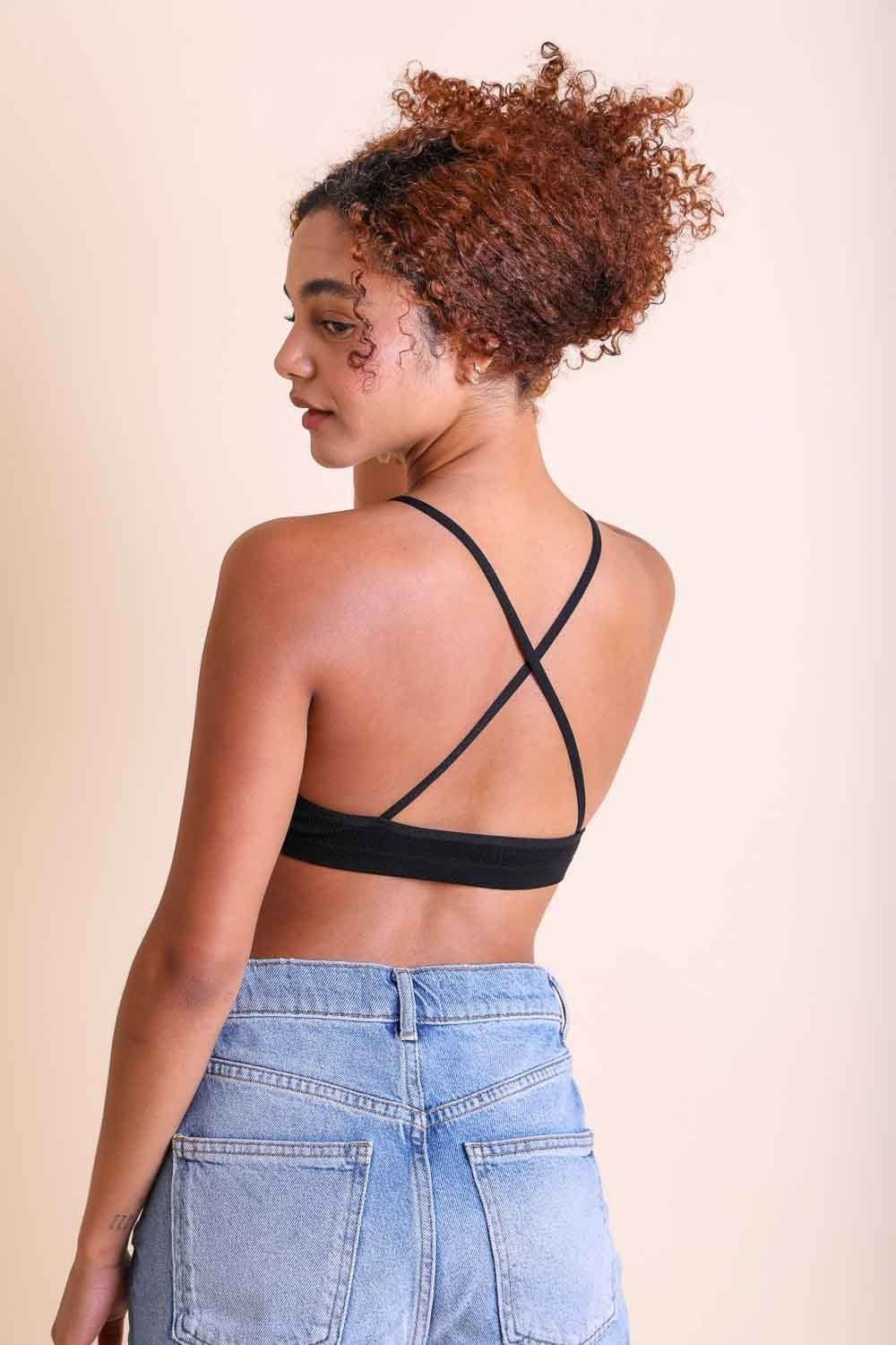 Rear view of a woman wearing a black Crochet Lace High Neck Bralette with cross-back straps and blue jeans