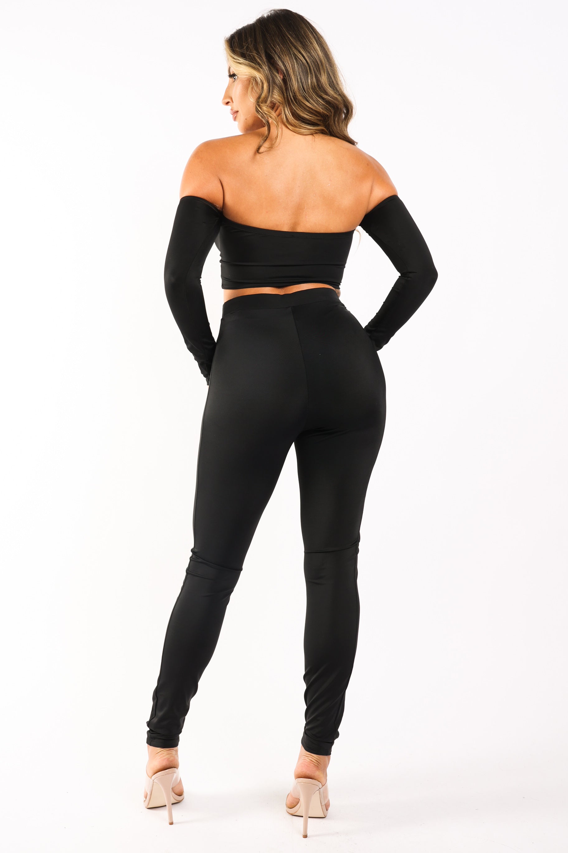 Back view of a woman wearing a black off-shoulder top and matching leggings