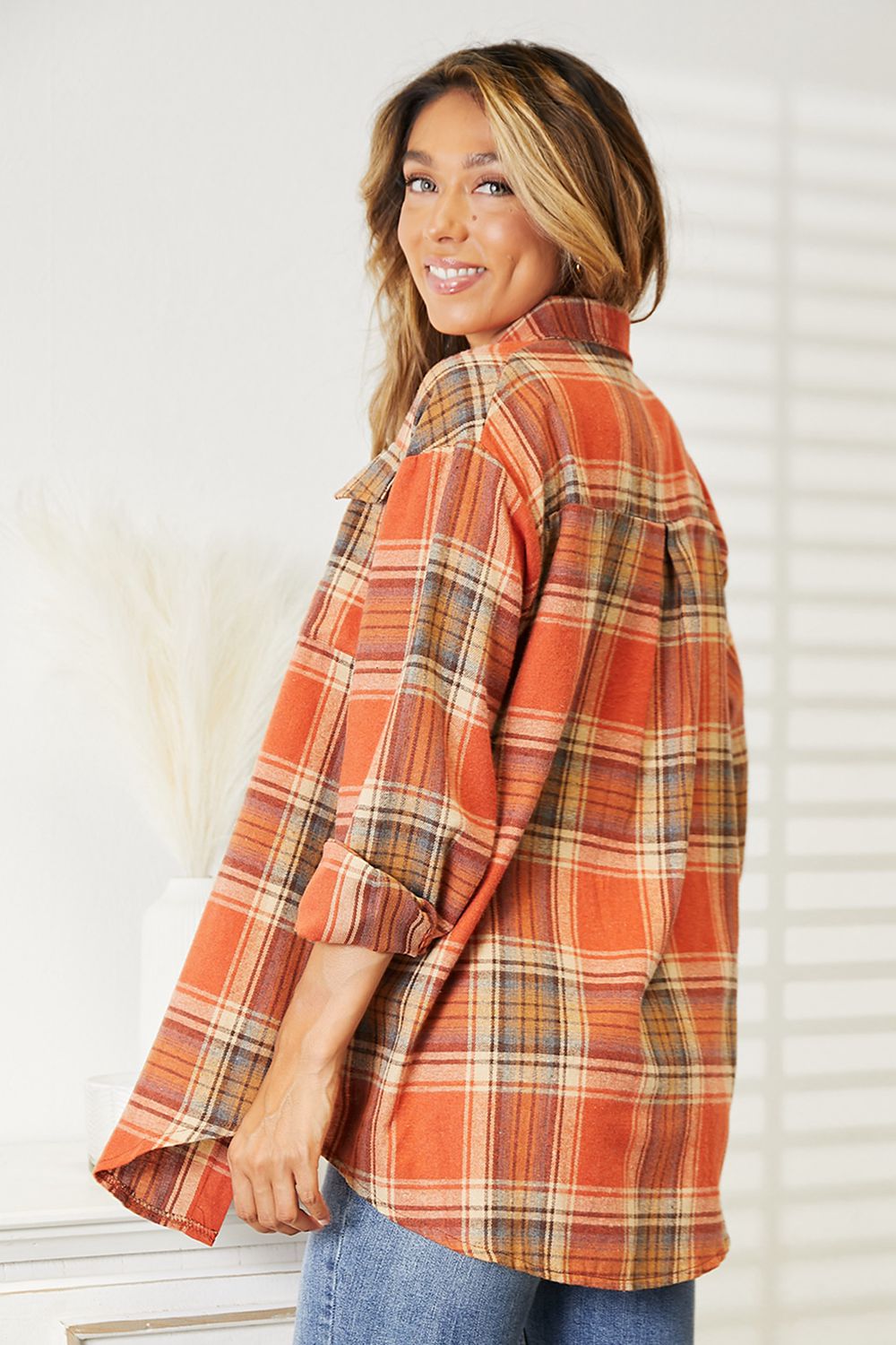 Woman wearing a Plaid Button-Front Relaxed Shirt, looking over her shoulder at the camera