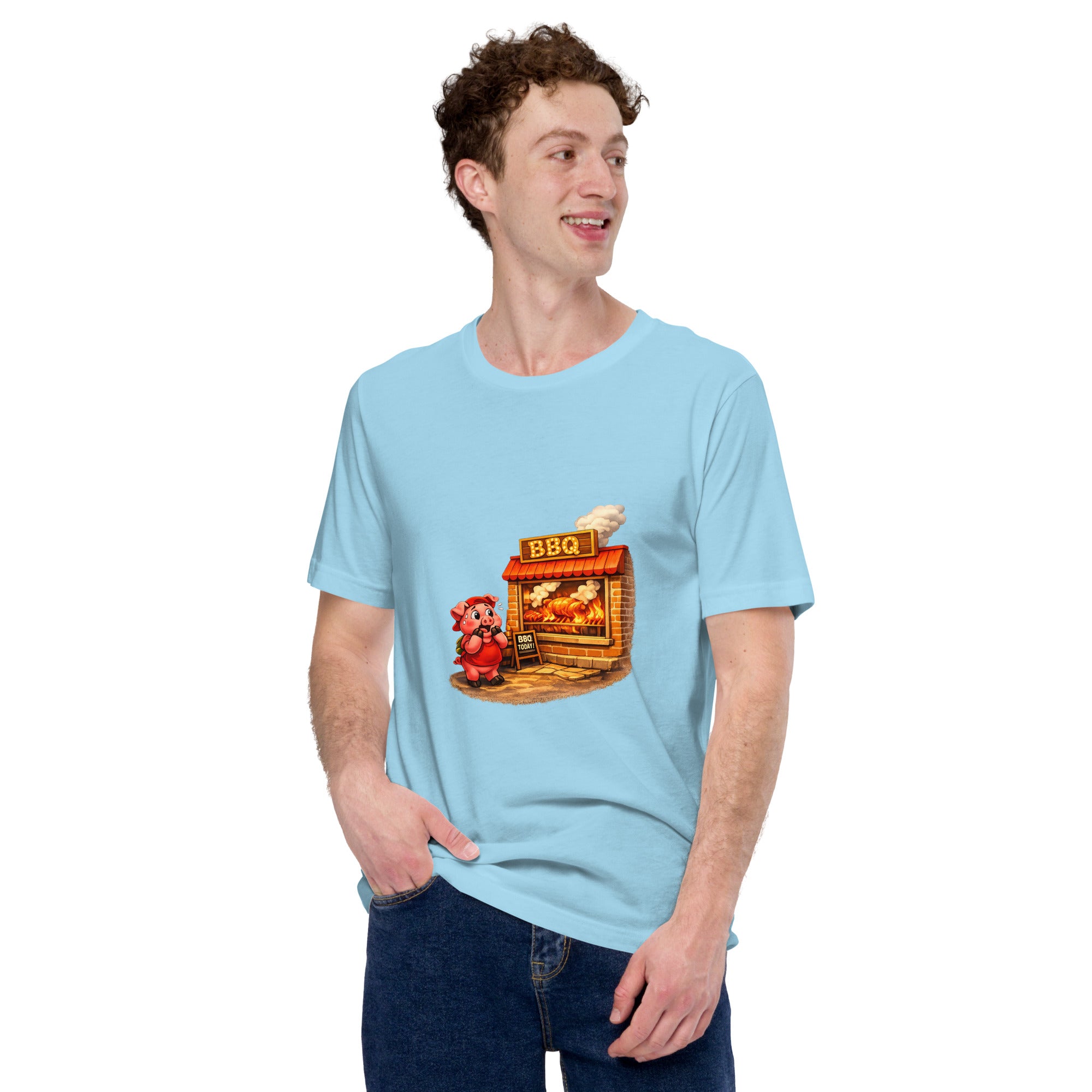 Man wearing a light blue Pig & BBQ Graphic Tee with a cartoon pig next to a BBQ stand